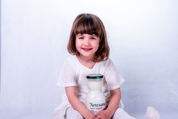 copil care tine in brate o sticla de lapte Artesana
